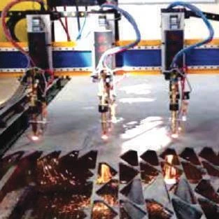 Multiple CNC cutting torches above a steel plate.