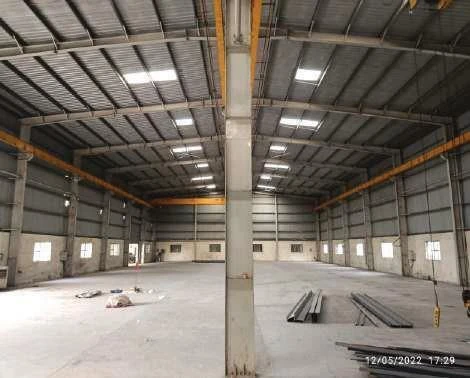 Interior of a high-bay workshop with overhead cranes.